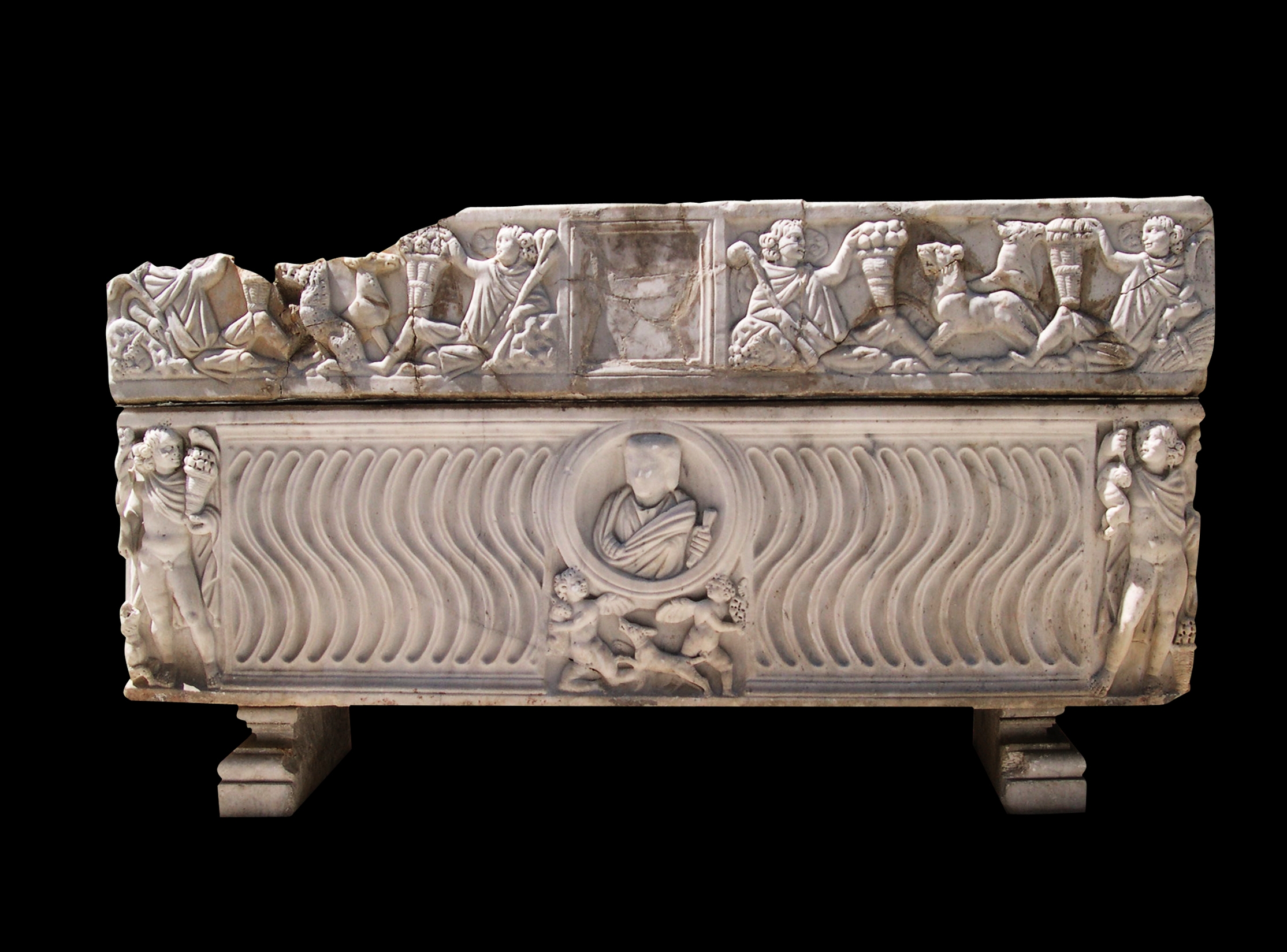 Strigilated sarcophagus with lid decorated by genii of the seasons